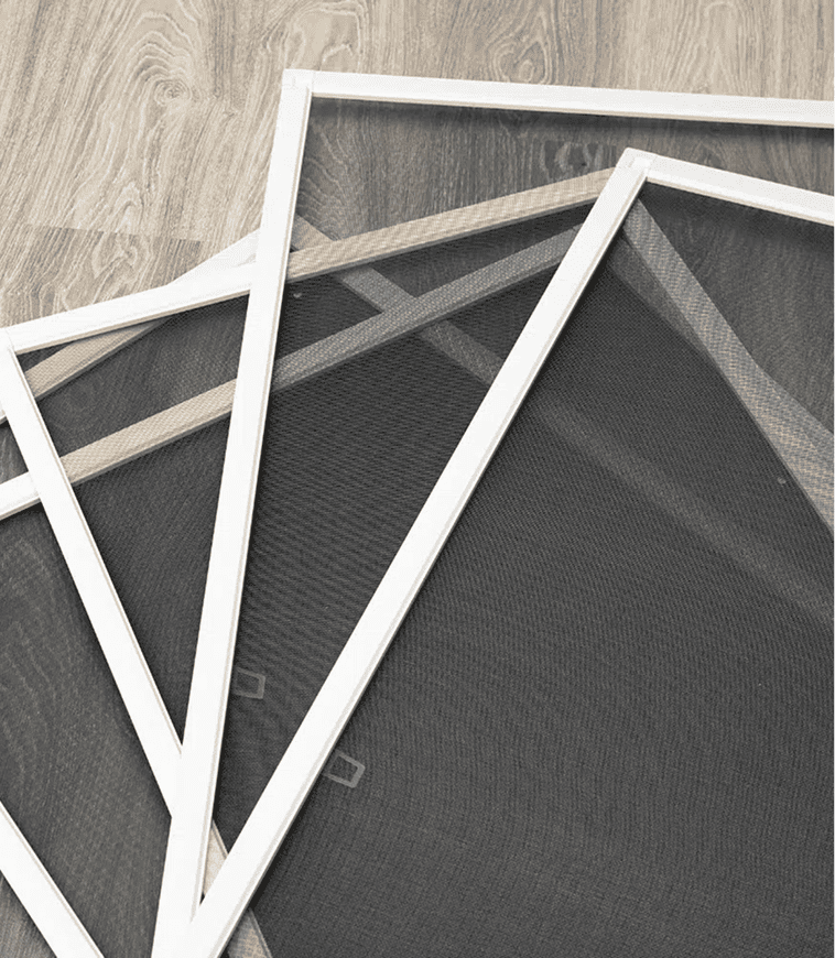 Drei rechteckige Fenstergitter mit weißem Rahmen sind auf einem hellen, holzgemusterten Fußboden geschichtet. Die Maschen der Schirme sind sichtbar und bilden ein Gittermuster.